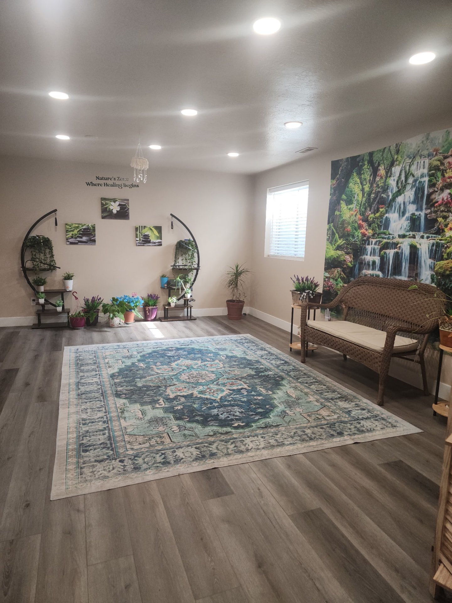Nature's Zone Spa reception room with plants and a waterfall mural